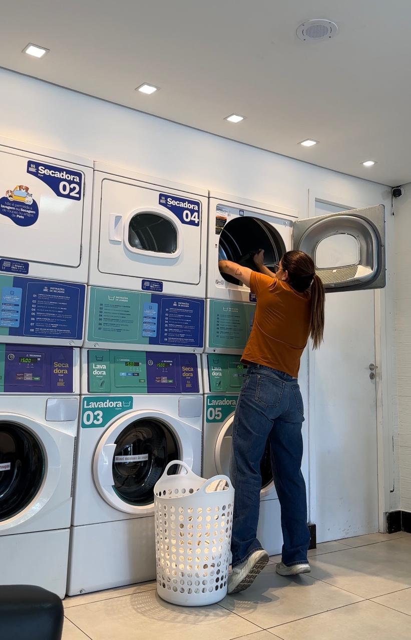 Cliente usando a secadora profissional na lavanderia A Gente Lava